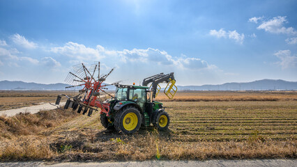 A view of Ganghwado's rice fields and a circular baler. Autumn rice fields after harvest. A view of Gyodongdo Island in Ganghwado. Korean traditional rice farming.