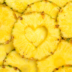 Heart-shaped pineapple. Yellow slices of tropical pineapple. Summer vacation concept.