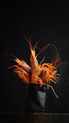 Delicious tiger prawns. Composition of boiled prawns in a metal box. On a black slate background.