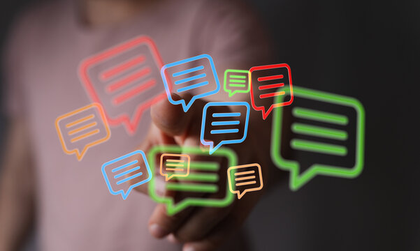 Close up of hand interacting with digital chat bubbles, representing online communication and tech solutions. - Powered by Adobe