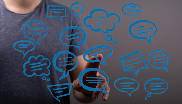 Close up of a hand touching blue chat bubble icons, symbolizing online conversations, communication, and digita - Powered by Adobe