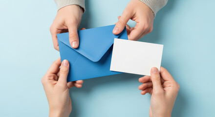 hands exchanging blue envelope and blank white card on pastel background symbolizing communication, invitation, message and correspondence