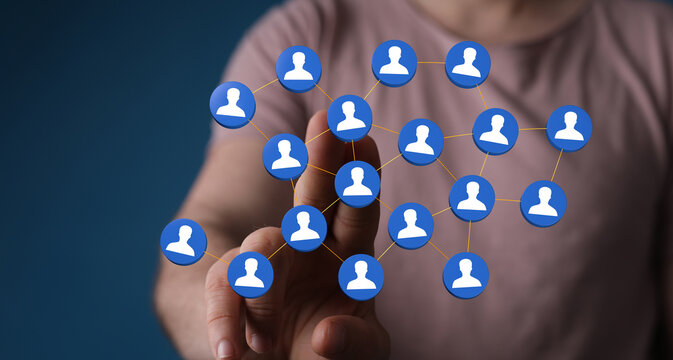 Person's hand touching a network of connected people icons. Represents online community, global network, and human interaction. Ideal for tech,