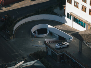 Aerial view of the winding entrance to a parking garage next to a white building, Thimphu, Bhutan.