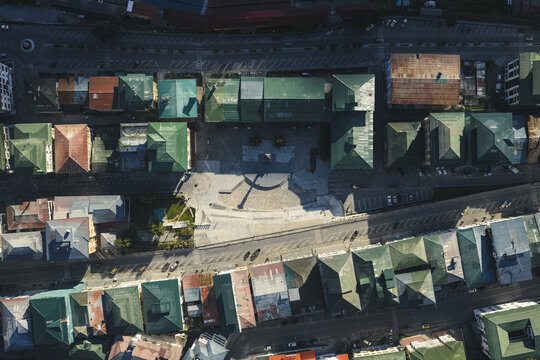 Aerial view of the Clock Tower square and rooftops painted in various shades of green and brown, creating a vibrant mosaic across the urban landscape, Thimphu, Bhutan.