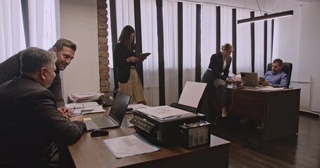 Multigenerational business associates collaborate in a modern office, utilizing technology and teamwork to achieve their goals. This diverse team represents experience and innovation.