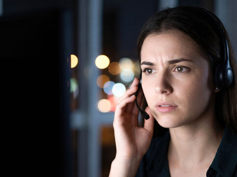 Helpline operator woman with headset working late night crisis support call center mental health suicide prevention consulting depression emergency service volunteer empathy dark office background