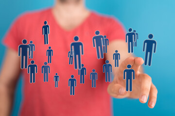 Hand touching digital people symbols, representing teamwork, communication, and social connections in a virtual