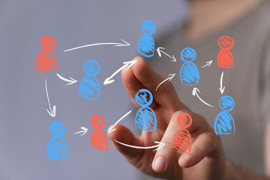 Person's hand interacts with a digital display showing a dynamic network of human icons. Illustrates communication, social networking, team coll - Powered by Adobe