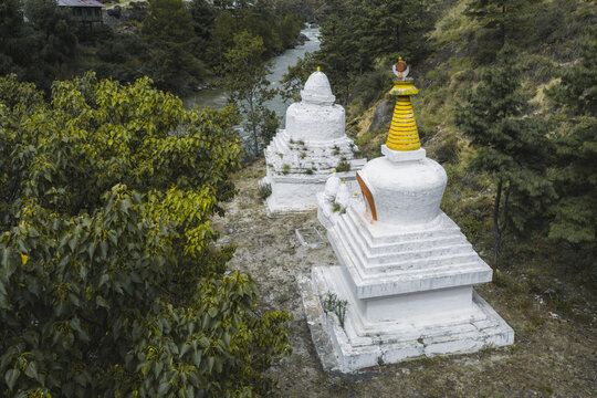 Aerial view of the stupas sitting serenely near the Paro-Thimphu Highway, where the river flows, juxtaposing the natural with the man-made, Paro, Bhutan.
