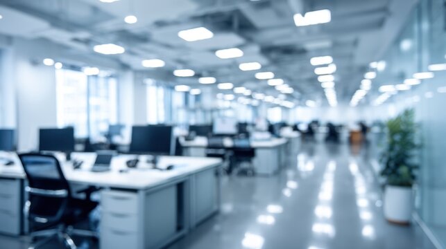 Blurred modern open plan office interior with workstations computers and glass partitions