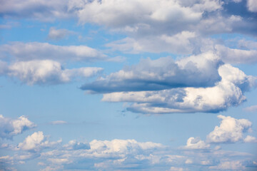 White altocumulus clouds are in blue sky on a daytime, natural background photo