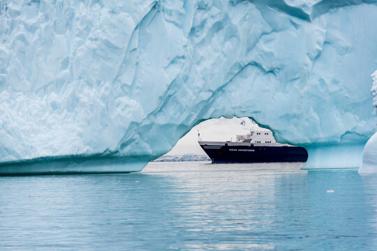 Cuverville Island, Antarctic Peninsula - January 31, 2024. Antarctic expedition ship the ocean adventurer is anchored near Cuverville Island on the Antarctic peninsula and framed by an iceberg in the