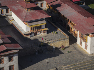 Haa, Bhutan - 26 September 2025: Aerial view of Haa Dzong's majestic architecture under a golden sun, casting shadows across its courtyard.