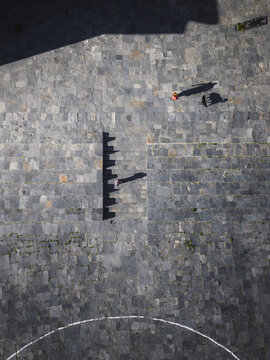 Aerial view of the stone-paved courtyard casting stark shadows from a sundial, creating a geometric dance of light and dark, Haa, Bhutan.