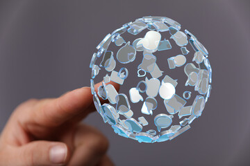 Abstract image showing hand holding a holographic sphere formed of speech bubbles. Represents communication, social media, connection, and ideas