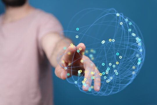 Close-up of a hand reaching out to a 3D digital network globe, symbolizing connection, technology, and global concepts. Suitable for business an