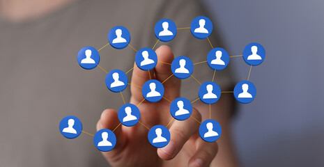 Hand interacting with digital network connections of people, representing social media, networking, teamwork an