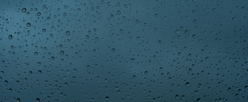 A rainy day window view. Rain drops on window. Condensed rain drop on the car glass window on a rainy day. Dew moisture condensation on wet mirror background. Fresh weather. Water raindrop bg