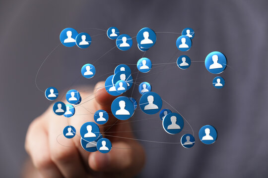 Abstract image showing a digital network or social connection with person's finger touching a sphere containing a person icon.