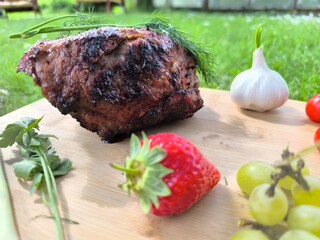 Grilled meat on a board and fresh vegetables