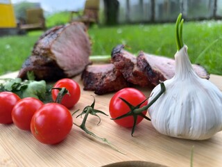 Grilled meat on a board and fresh vegetables