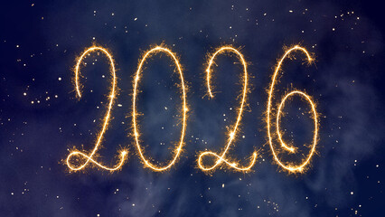 Fototapeta premium 2026 Happy New Year, written with bright golden sparkler on a dark blue starry night background with abstract smoke and shining dust