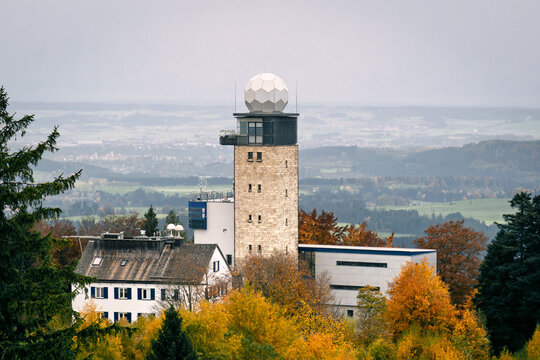 Historic weather station tower atop Hohenpei&szlig;enberg, radar dome and labs amid autumn forest, symbolizing climate research, ideal for science and environmental topics.