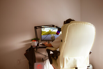 teenager plays a computer game at a table
