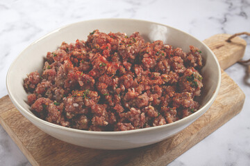 raw minced meat, marinated with spices and herbs, in a bowl, minced meat with spices, top view, homemade, no people,