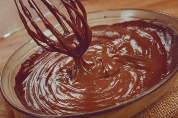 a bowl of chocolate dough, a whisk for whipping, baking, structure and consistency, homemade, top view, no people,