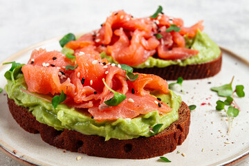 breakfast, Sandwiches with smoked salmon and avocado, on dark rye bread, with microgreens, on a marble table, homemade, no people,