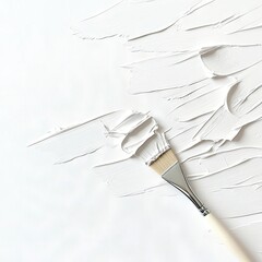 A paintbrush with white paint is being used to create textured strokes on a white canvas. The lighting is bright and clean, highlighting the texture of the pain