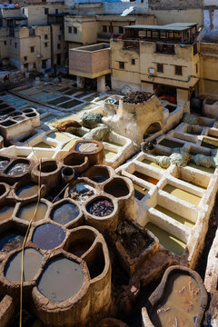 Traditional outdoor tannery with numerous circular pits for leather processing in a historic setting. Fez, Fez-Meknes, Northern Inland Morocco