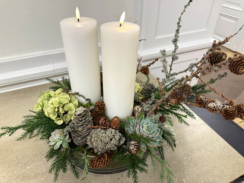 Christmas Advent wreath with two lit white candles on table