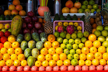 Vibrant display of assorted tropical fruits stacked in colorful rows at a market stall. Marrakesh, Morocco