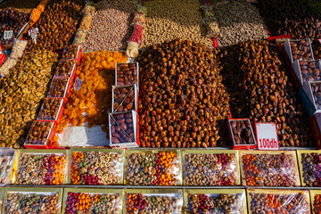 Varied selection of colorful dried fruits and nuts displayed at an outdoor market stall. Marrakesh, Morocco