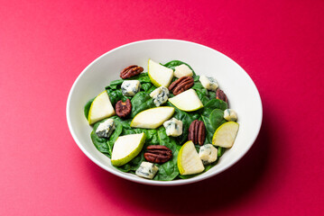 Salad with spinach, blue cheese, pear, and nuts. Healthy eating. Vegetarian food.