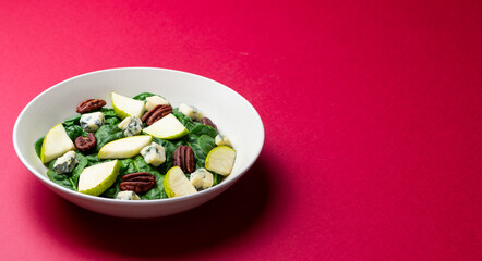 Salad with spinach, blue cheese, pear, and nuts. Healthy eating. Vegetarian food.