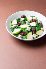 Salad with spinach, blue cheese, pear, and nuts. Healthy eating. Vegetarian food.