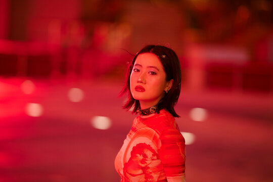 Woman in a red dress with bold makeup in a vibrant, red-hued setting Shanghai, China