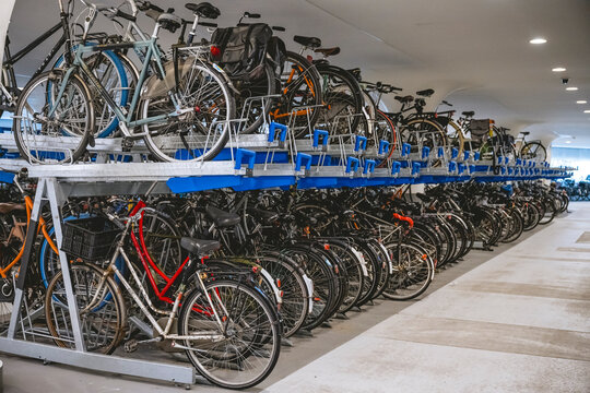A large indoor bicycle parking area with many parked bicycles on multi-level racks. Amsterdam,. Netherlands