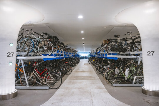 Indoor bicycle parking area with stacked bikes on dual-level racks in a modern setting. Amsterdam,. Netherlands