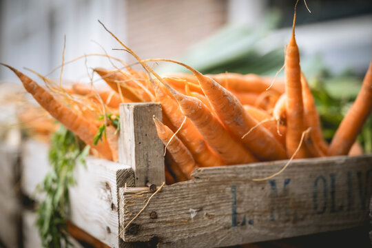 Fresh carrots stacked in a rustic wooden crate on display at a market. Amsterdam,. Netherlands