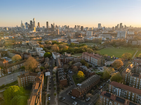 Aerial view of a cityscape with skyscrapers and residential areas during sunset. London, UK