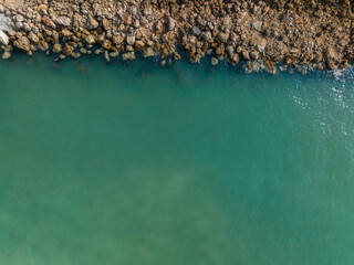Aerial view of a rocky shoreline meeting calm, turquoise ocean waters. Cartagena, Colombia