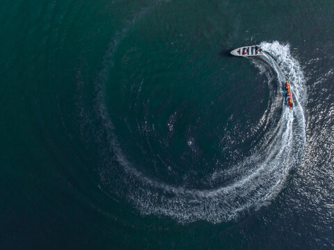 Aerial view of a speedboat making a circular pattern on dark blue water. Cartagena, Colombia
