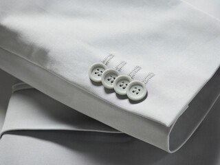 Close-up of a folded white shirt with neatly aligned buttons.