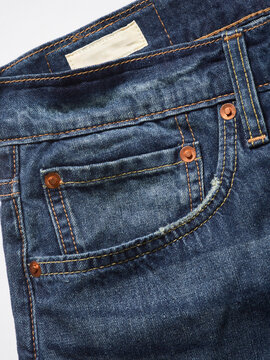 Blue denim jeans with visible stitching and copper rivets close-up.