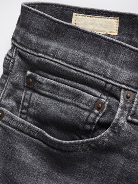 Close-up of dark denim jeans with visible front and coin pockets detailing.